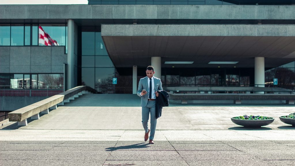 Business executive walking from office building.