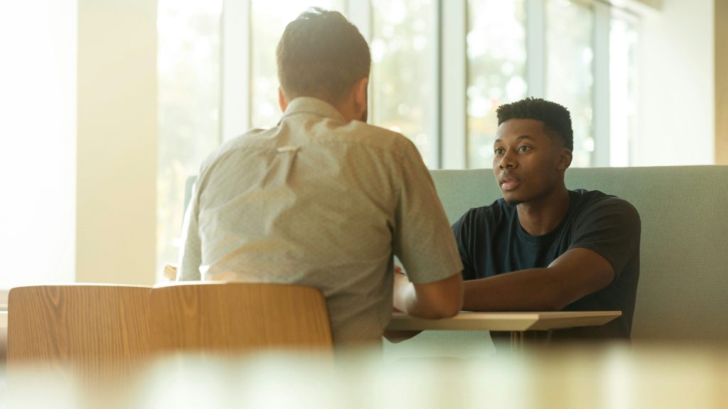 Two men engaged in a serious one-on-one conversation.