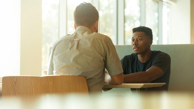 Two men engaged in a serious one-on-one conversation.
