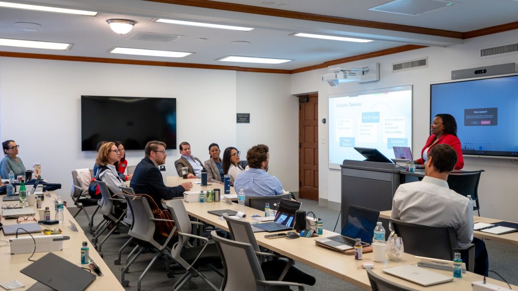 Instructor presenting material to a class of MBA students in a lecture hall.